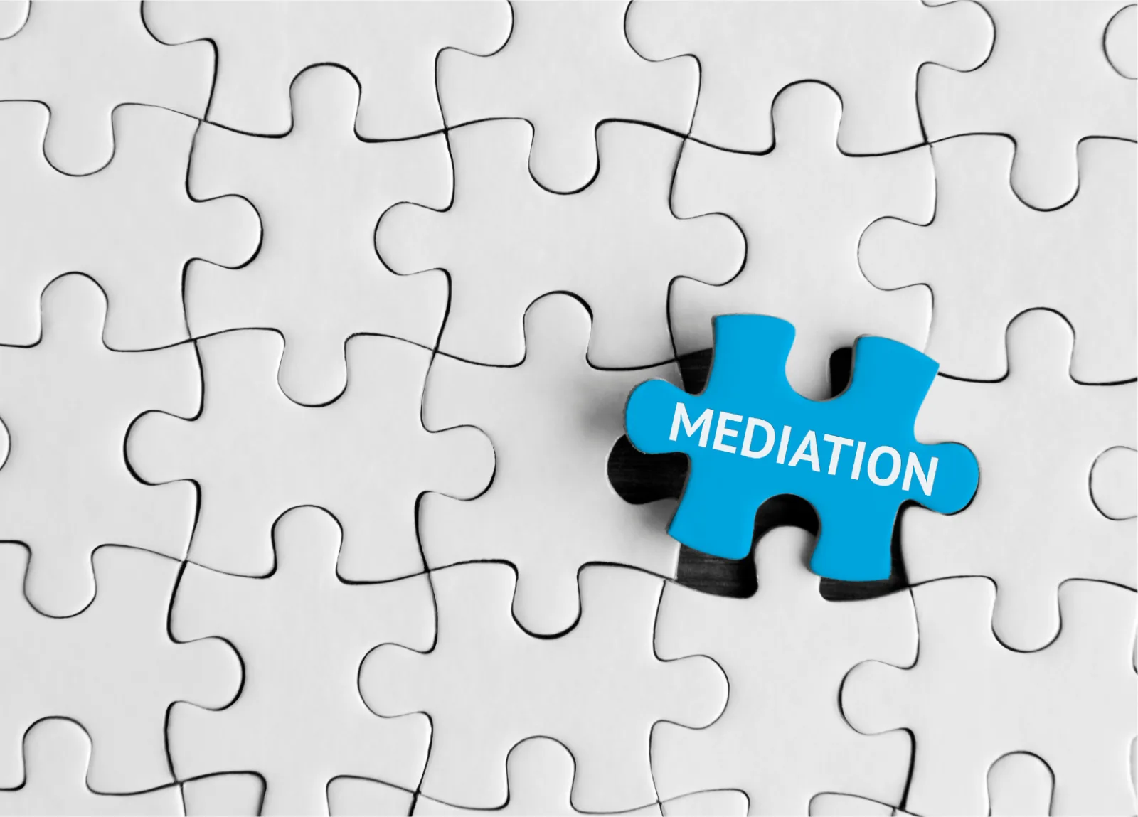 Weißes Puzzle, in dem ein blaues Teil mit der Aufschrift „Mediation“ liegt.