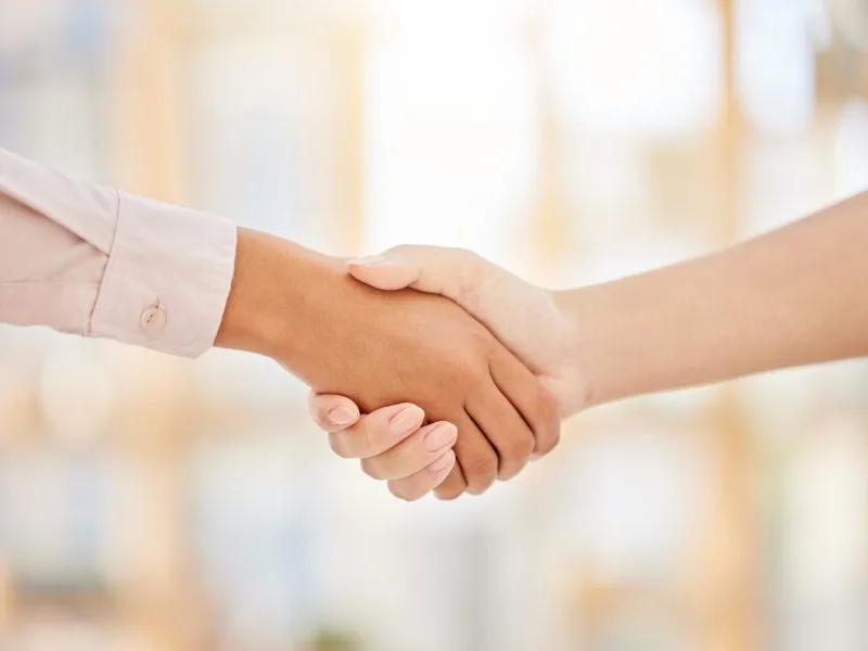 Zwei Menschen reichen sich die Hand.