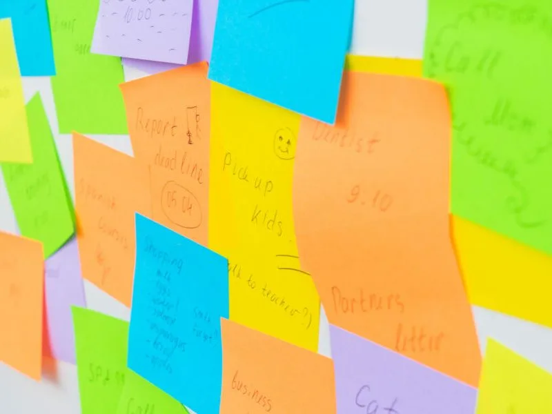 Viele bunte, beschriftete Haftnotizen an einer Wand.